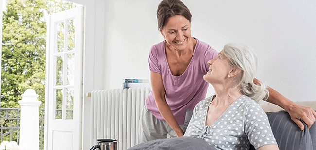 Betreuerin lacht mit Seniorin, 24h-Pflege in Neuss